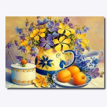 Diamond painting jonka kuvassa on poydalla keltaisia kukkia vesikannun sisalla.